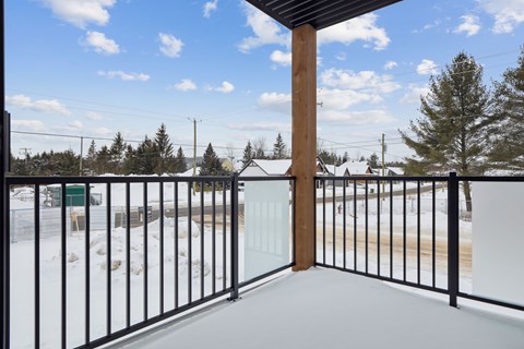 A snowy landscape with a wooden post and a metal fence.