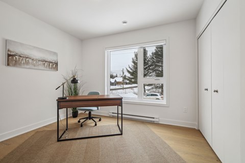 A room with a desk and a painting on the wall.