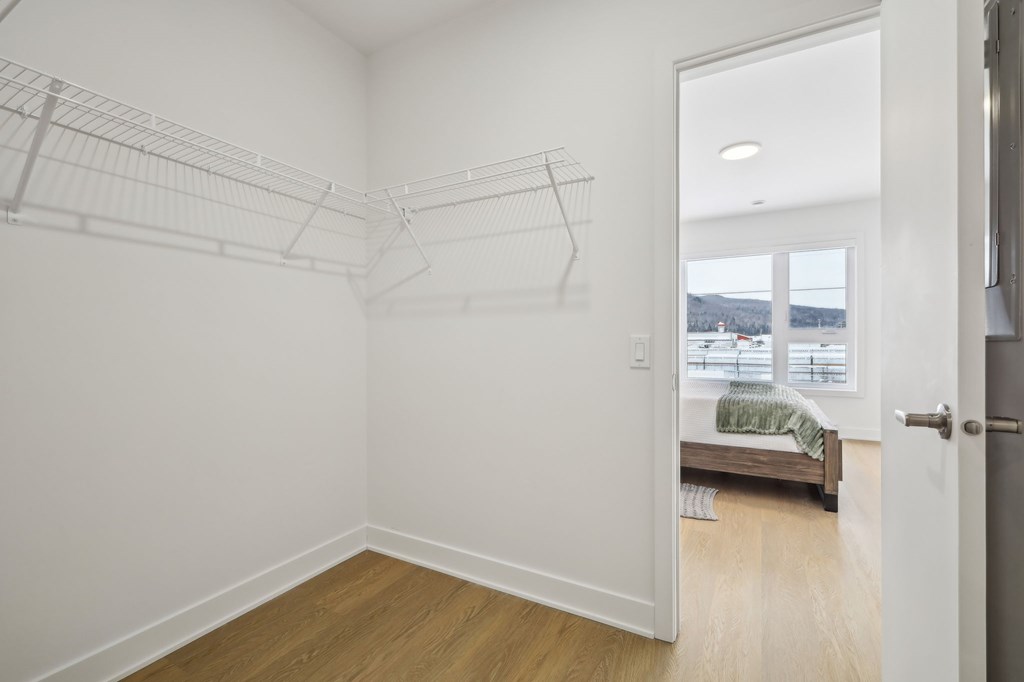 A white bedroom with a bed and a window.