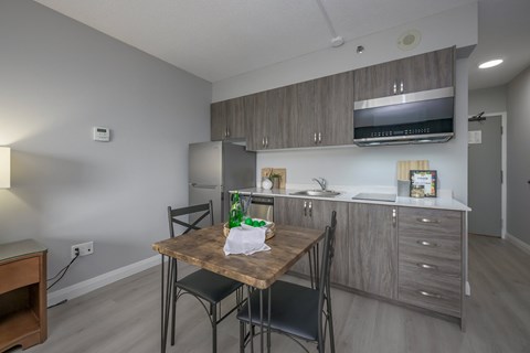 A kitchen with a table and chairs in the foreground.