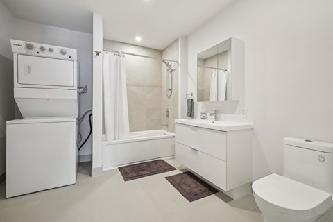 A white bathroom with a toilet, sink, and bathtub.