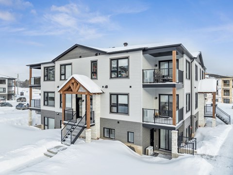 A large house with a balcony and a deck covered in snow.