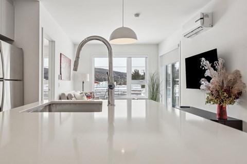 A modern kitchen with a large island and a view of the outdoors.