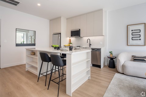 A modern kitchen with white cabinets and a large island.
