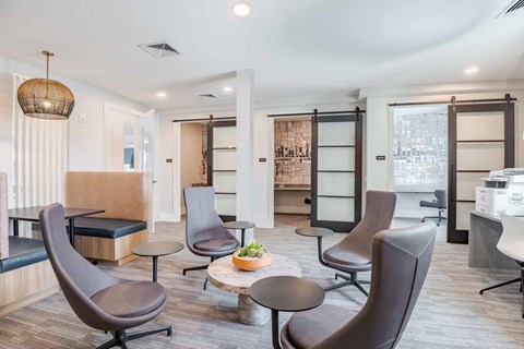 A modern living room with brown chairs and a wooden table.