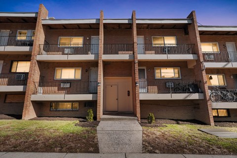 A multi-story apartment building with a brown door and balconies.