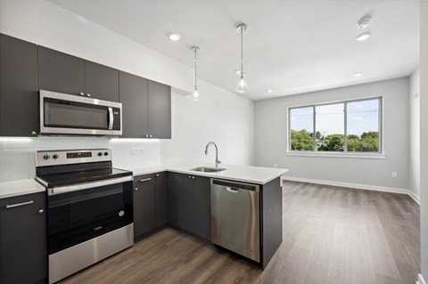 A modern kitchen with dark brown cabinets and stainless steel appliances.