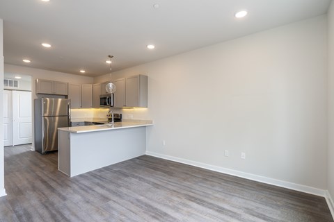 A kitchen with a refrigerator, microwave, and oven.