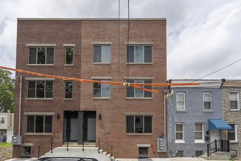 A red brick building with a grey door and windows.