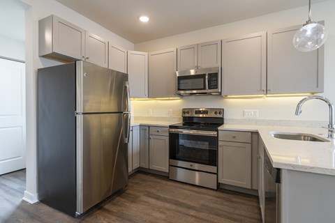 A kitchen with a stainless steel refrigerator, oven, and microwave.
