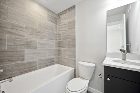 A bathroom with a white toilet and a white bathtub.