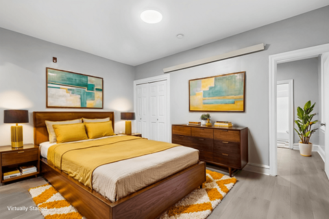 A bedroom with a large bed and two nightstands.