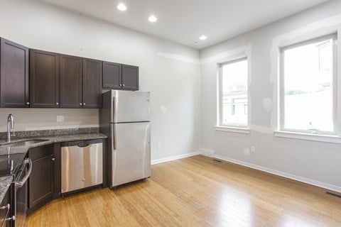 A kitchen with wooden floors and stainless steel appliances.