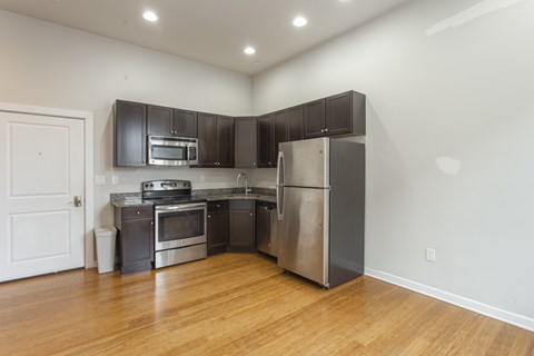 A kitchen with stainless steel appliances and wooden floors.