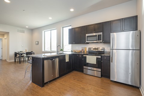 A modern kitchen with stainless steel appliances and black cabinets.