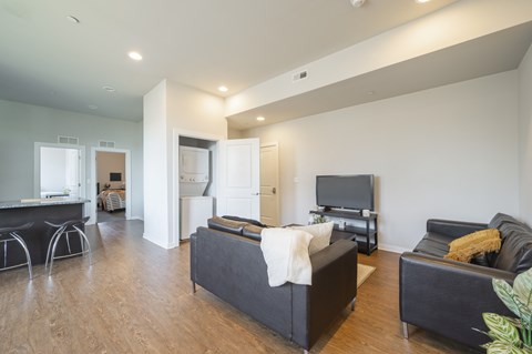 A living room with a black couch and a television.