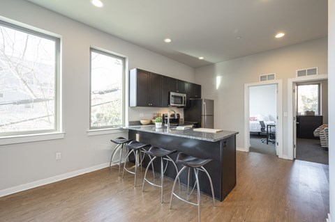 A kitchen with a bar stool and a counter.