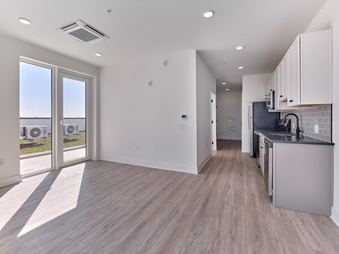 A modern kitchen with a view of the outdoors through large windows.