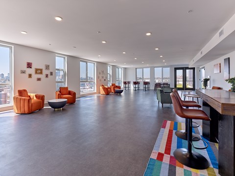 A spacious room with orange chairs and a long wooden table.