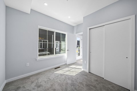 A room with a carpeted floor and a large window.