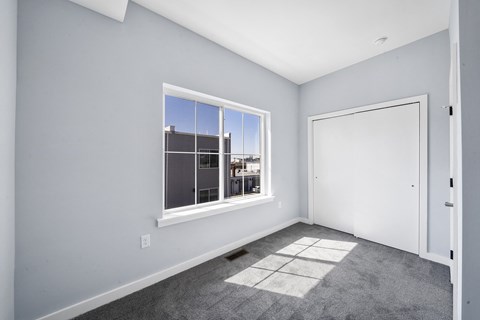 A room with a large window and a white door.
