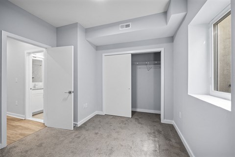 A room with a carpeted floor and a window on the right side.