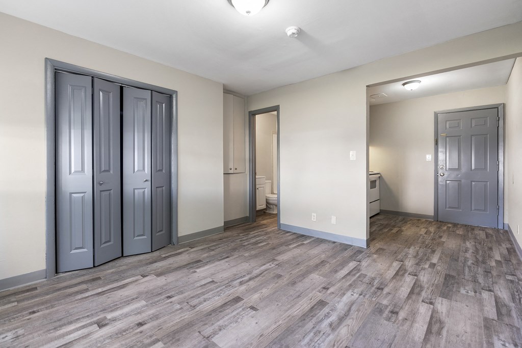 the living room and bedroom of a new home with gray doors and white walls