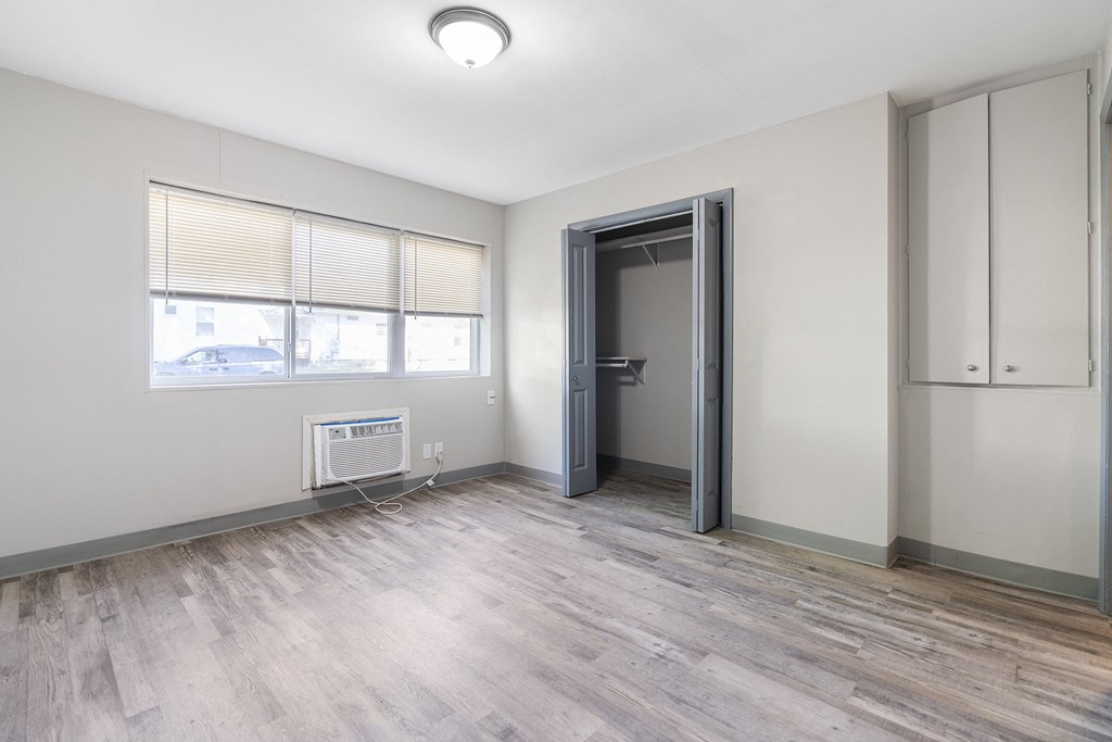 an empty living room with a door to a closet and a window