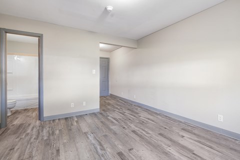 an empty living room with white walls and wood flooring