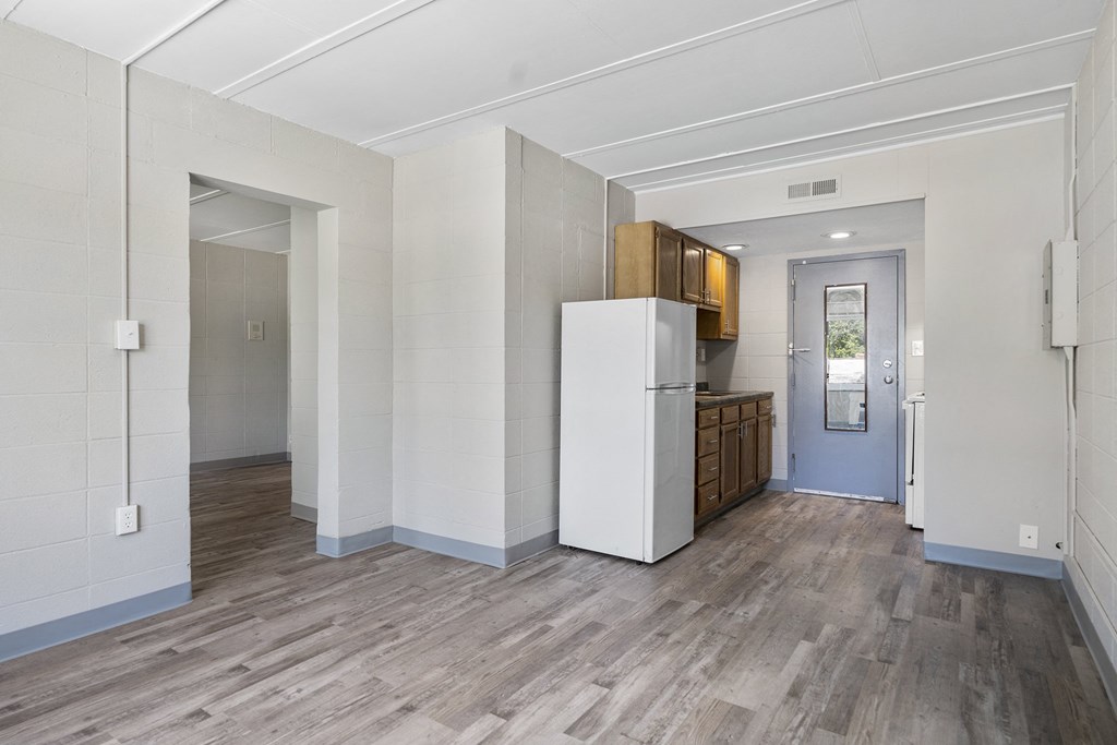 a kitchen with a refrigerator and a door to a hallway