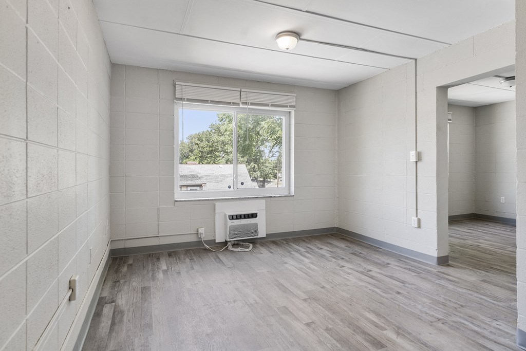 an empty room with white walls and a window