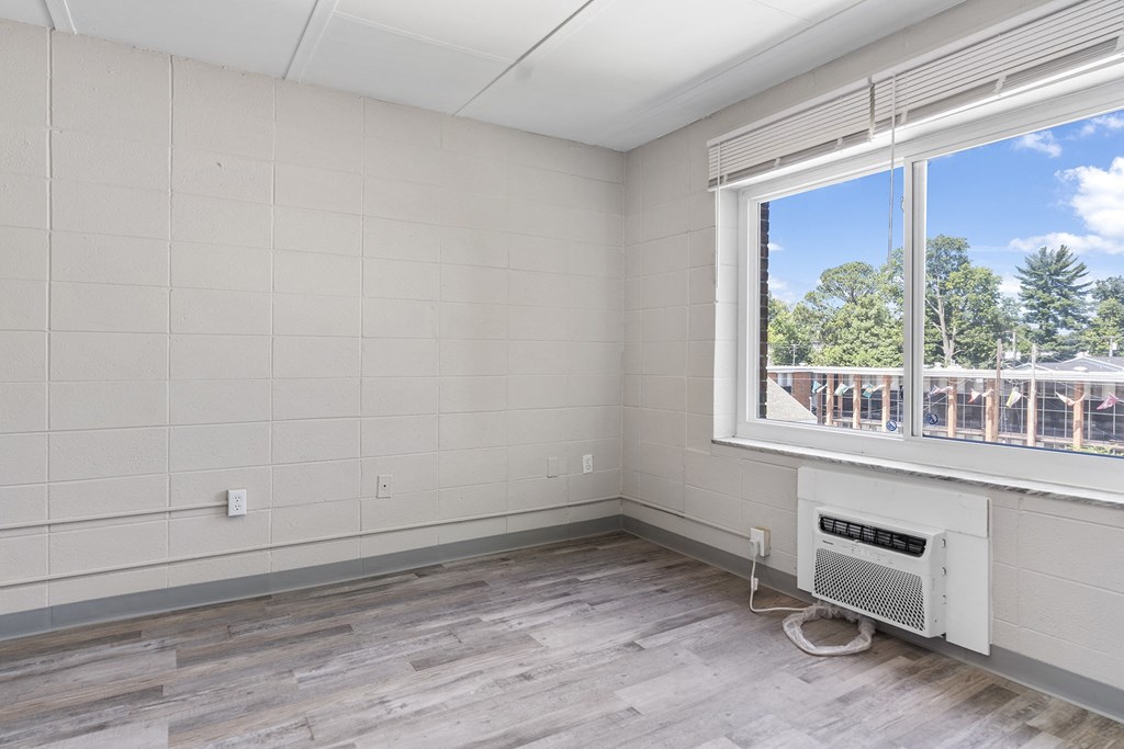 the living room has a large window and wood flooring