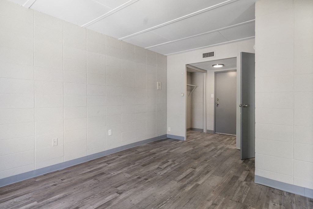 an empty room with white walls and wood floors
