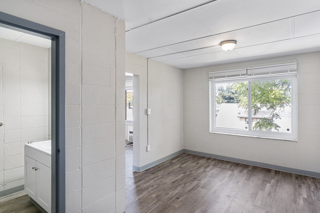 an empty room with a window and a mirror