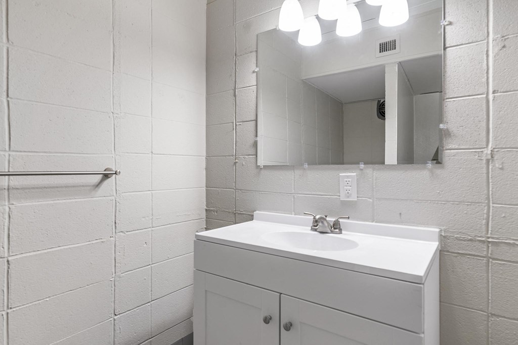 a white bathroom with a sink and a mirror