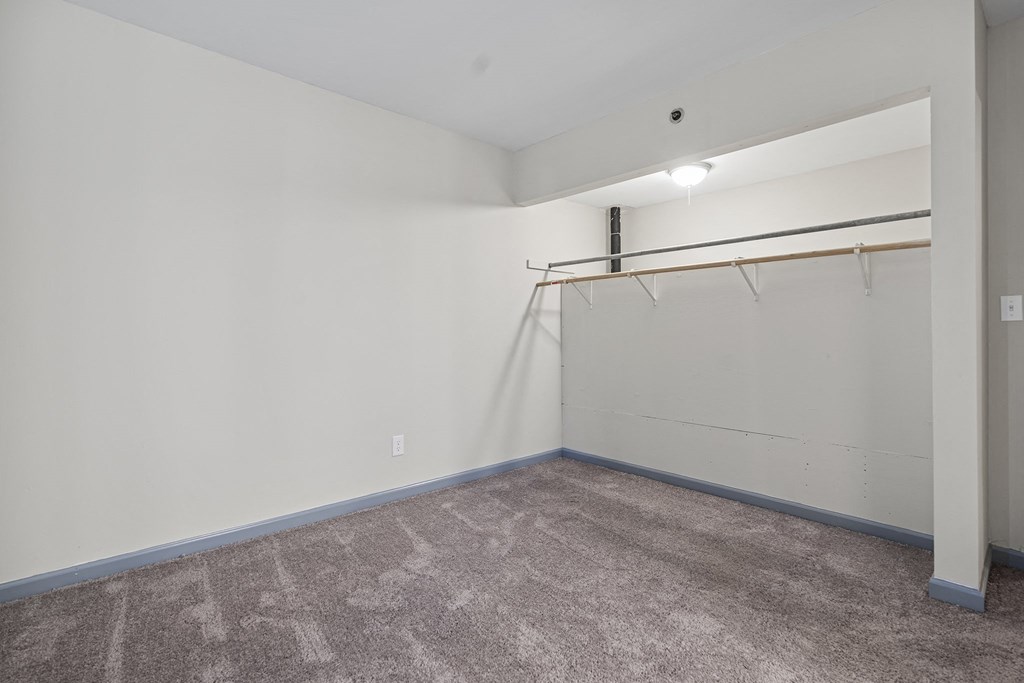 a room with carpet and a white wall and a garage door