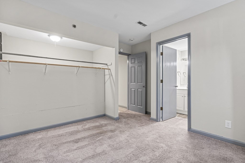 an empty room with a white wall and a door to a bathroom