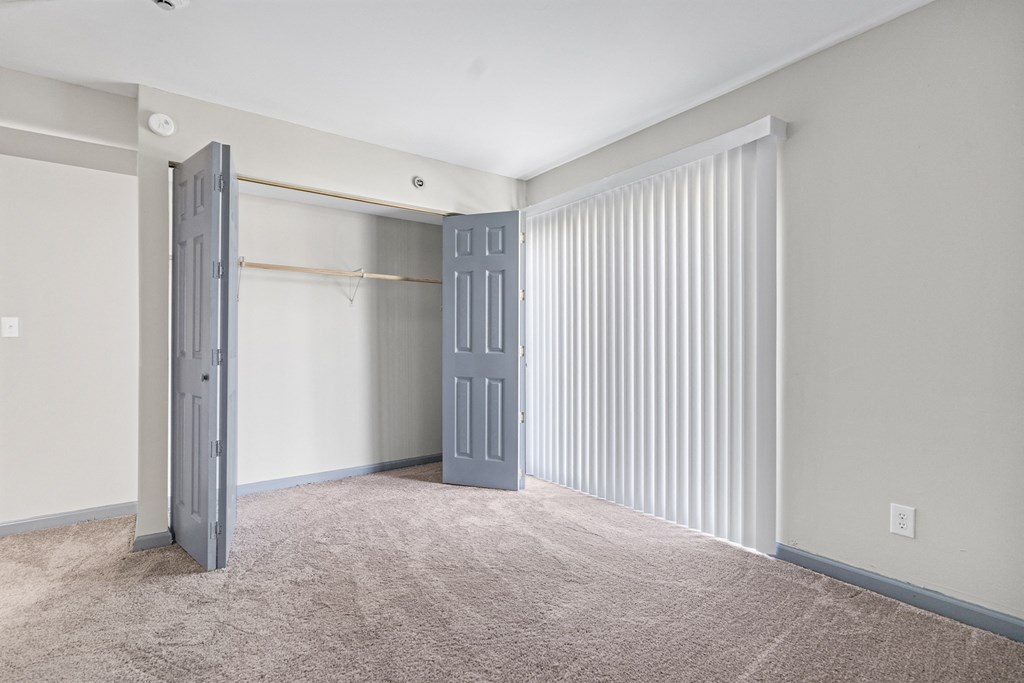 an empty living room with a door to a closet