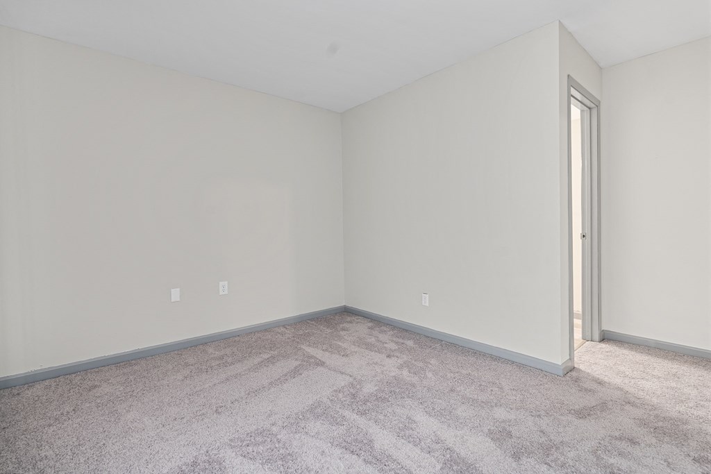 an empty room with carpet and a door