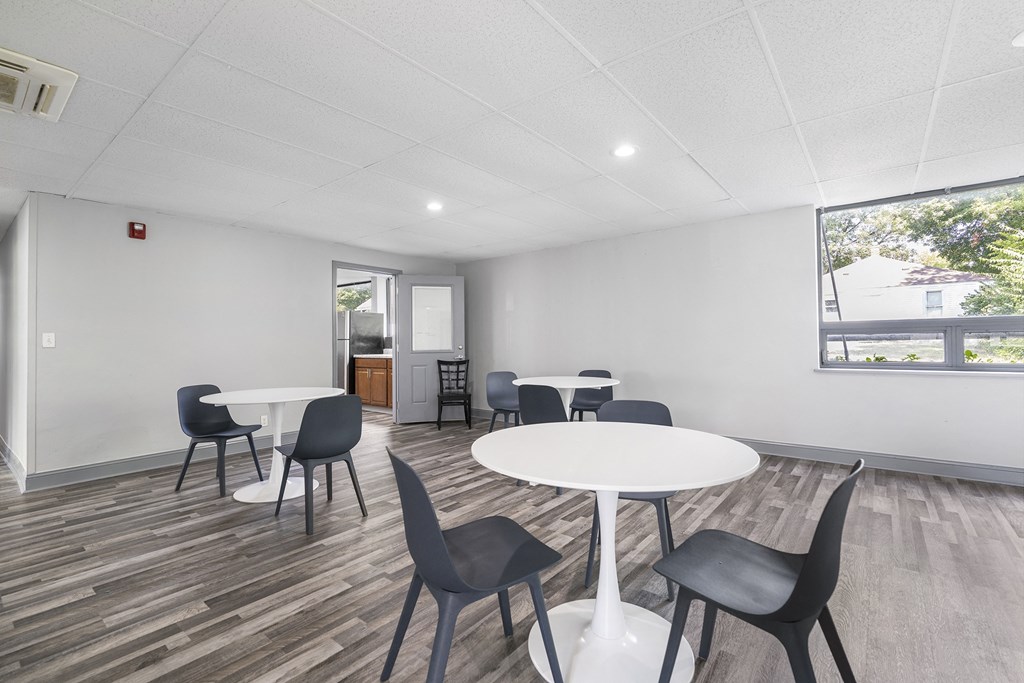 a community room with tables and chairs and a window