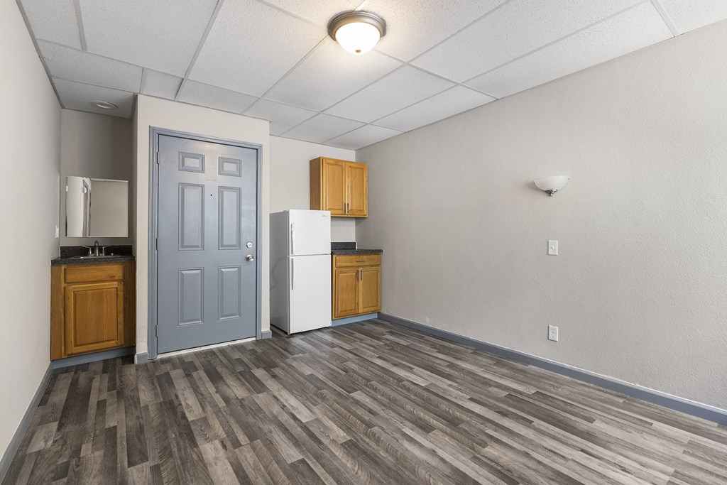 an empty room with a refrigerator and a door