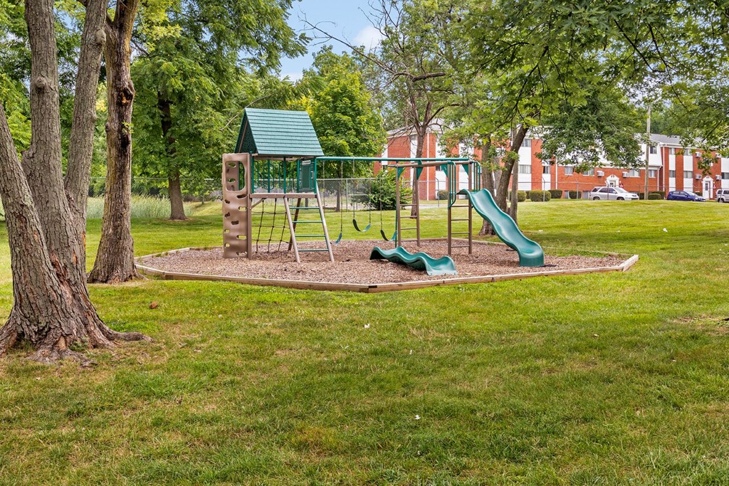 a playground with a swing set and slides in a park