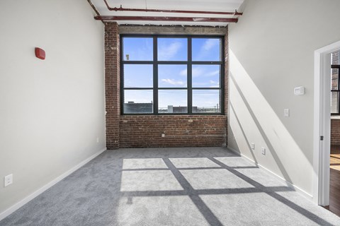 A room with a large window and a fire extinguisher on the wall.