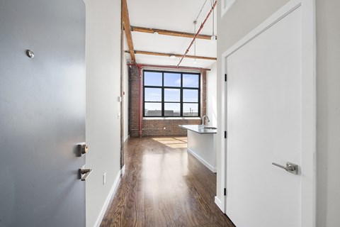 A long hallway with a window and a door on the right.