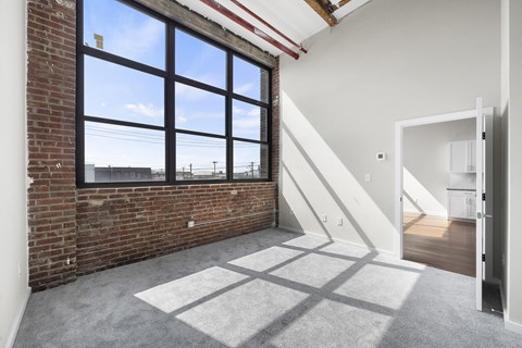 A room with a large window and a carpeted floor.