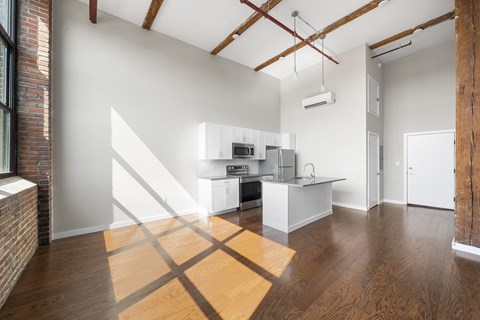 A kitchen with white cabinets and a wooden floor.