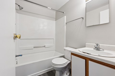 A white bathroom with a toilet, sink, and bathtub.