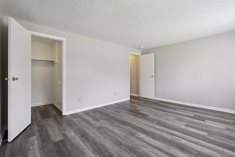 A room with a white door and a grey floor.