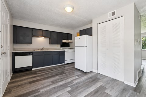 A kitchen with a white fridge and black cabinets.