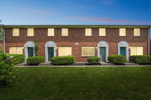 A red brick building with green doors and windows.